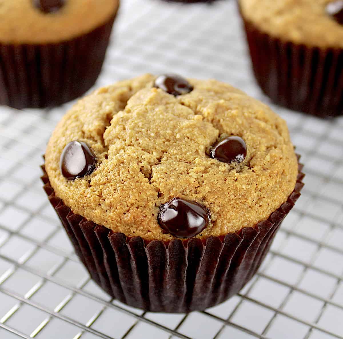 closeup of Gluten Free Banana Chocolate Chip Muffin in brown liner on cooling rack