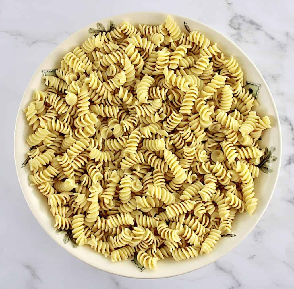 cooked rotini pasta in beige salad bowl