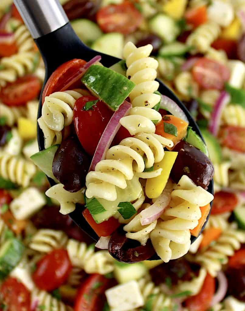 black serving spoon with Greek Pasta Salad