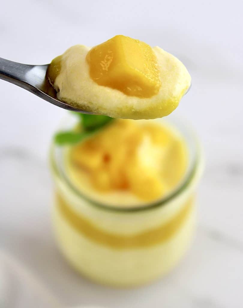 Mango Mousse with mango chunk on top in spoon