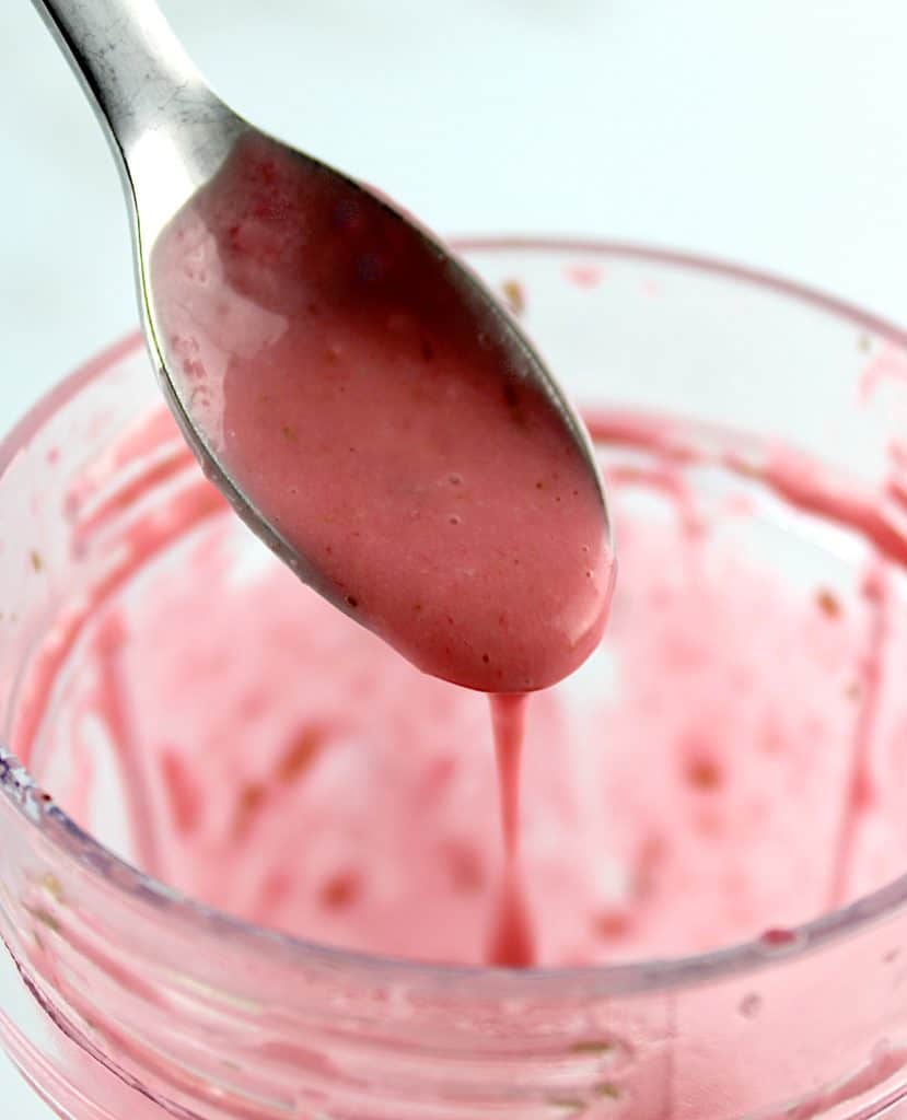 raspberry vinaigrette being spooned into cup