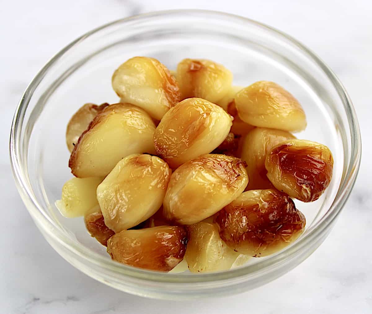 cloves of roasted garlic in glass bowl