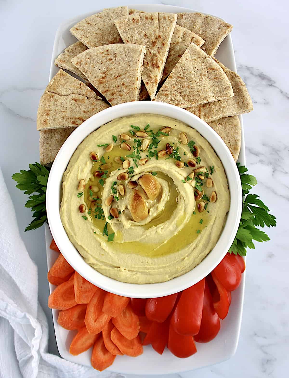 overhead view of Roasted Garlic Hummus with pita, carrots and red pepper on side