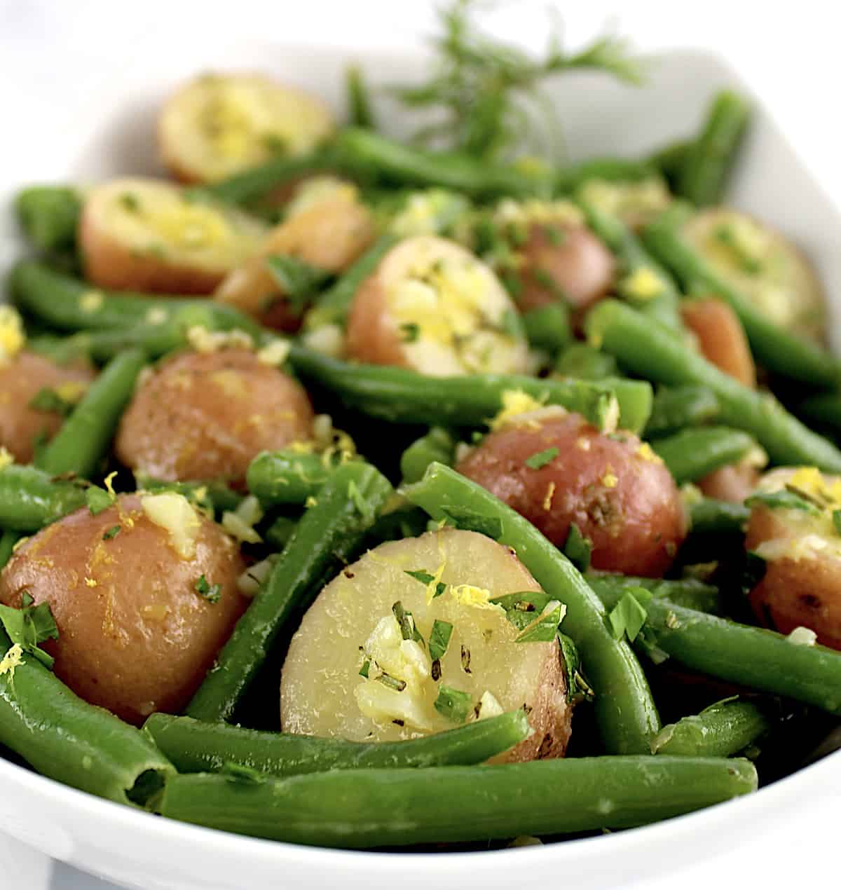 closeup of Garlic Potatoes and Green Beans in white bowl