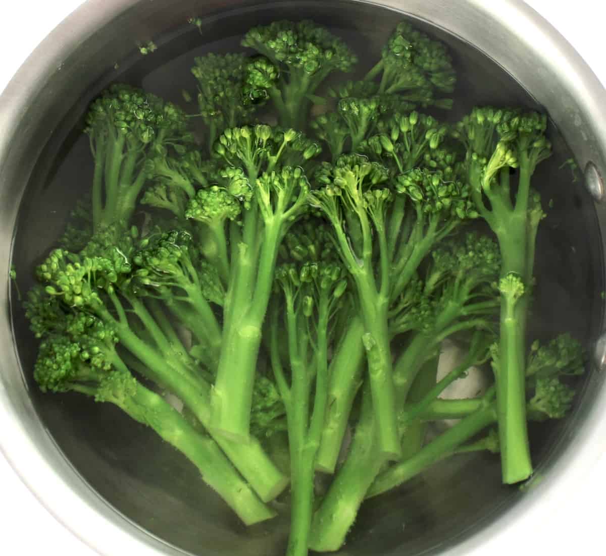 broccolini being boiled in saucepan