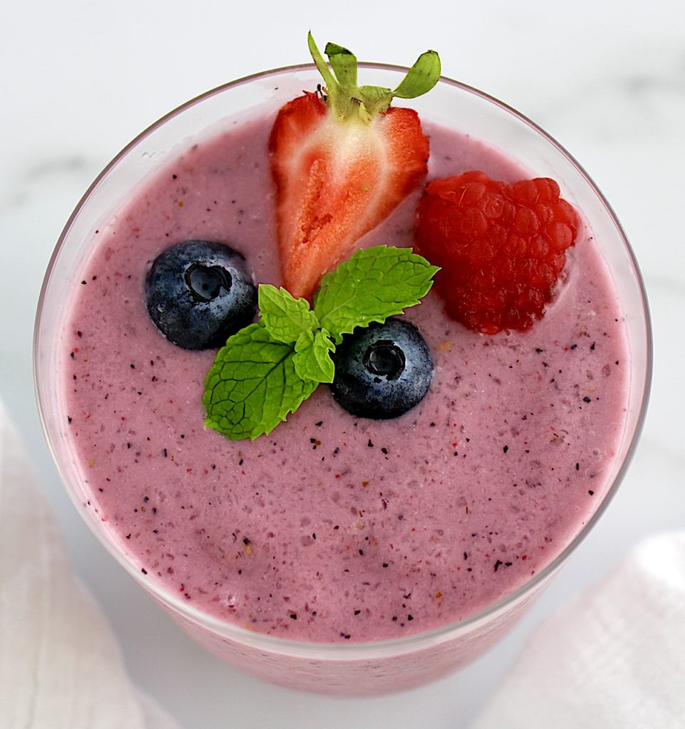 overhead view of Triple Berry Smoothie with berries and mint sprig on top