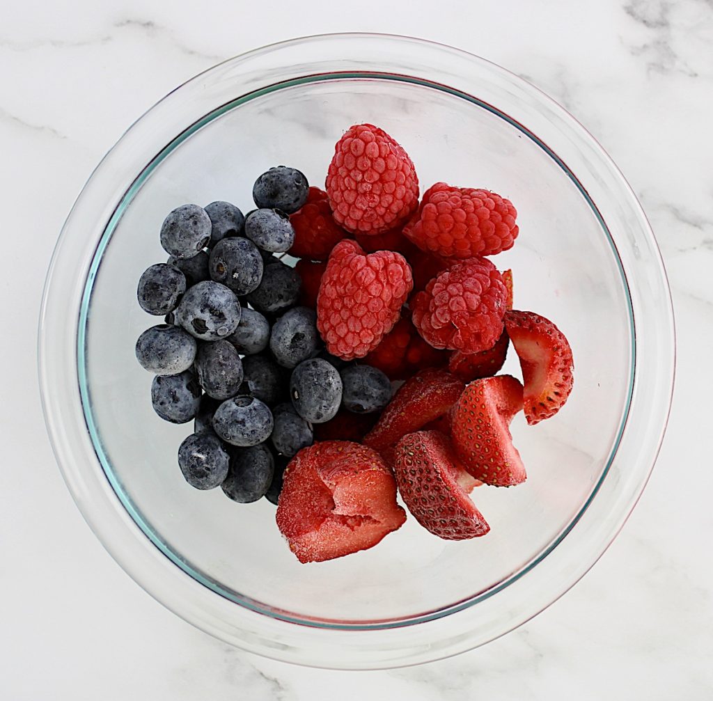 frozen blueberries raspberries and strawberries in glass bowl