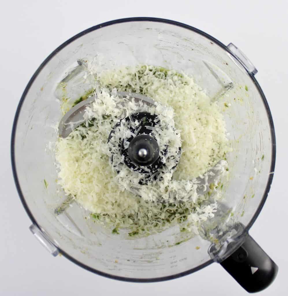 parmesan cheese and pesto sauce in food processor bowl