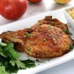 Air Fryer Bone in Pork Chop on white plate with parsley on side