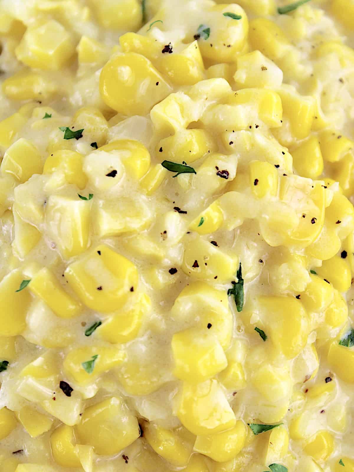 closeup of Creamed Corn with pepper and chopped parsley on top