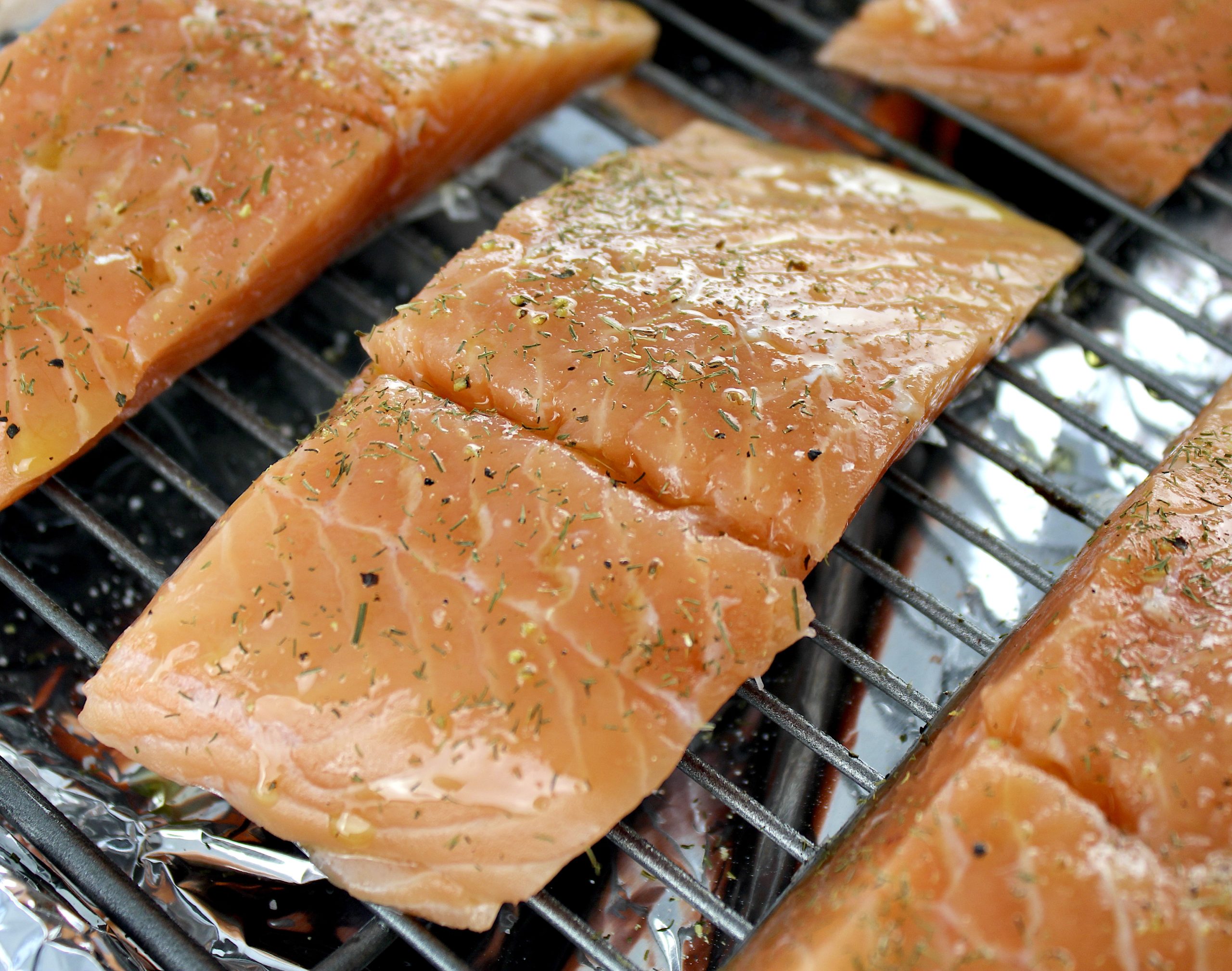 raw salmon pieces on baking rack with spices