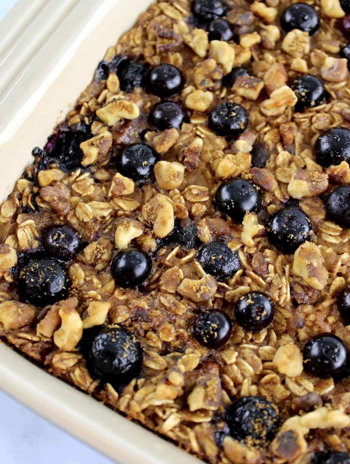 overhead view of Vegan Baked Oats with blueberries in beige casserole