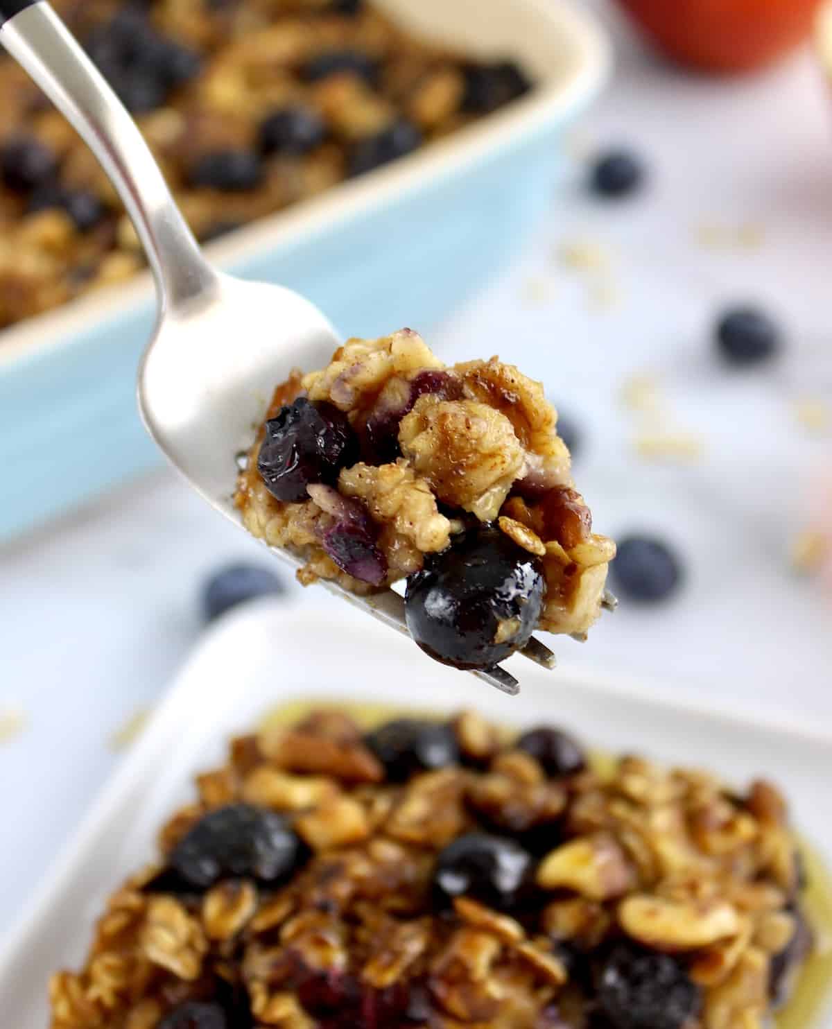 Vegan Baked Oats with blueberries held up with fork