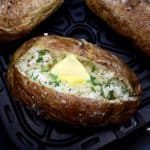 Air Fryer Baked Potato cut open with butter and chopped parsley