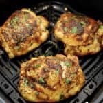 3 Air Fryer Chicken Thighs in air fryer basket with chopped parsley