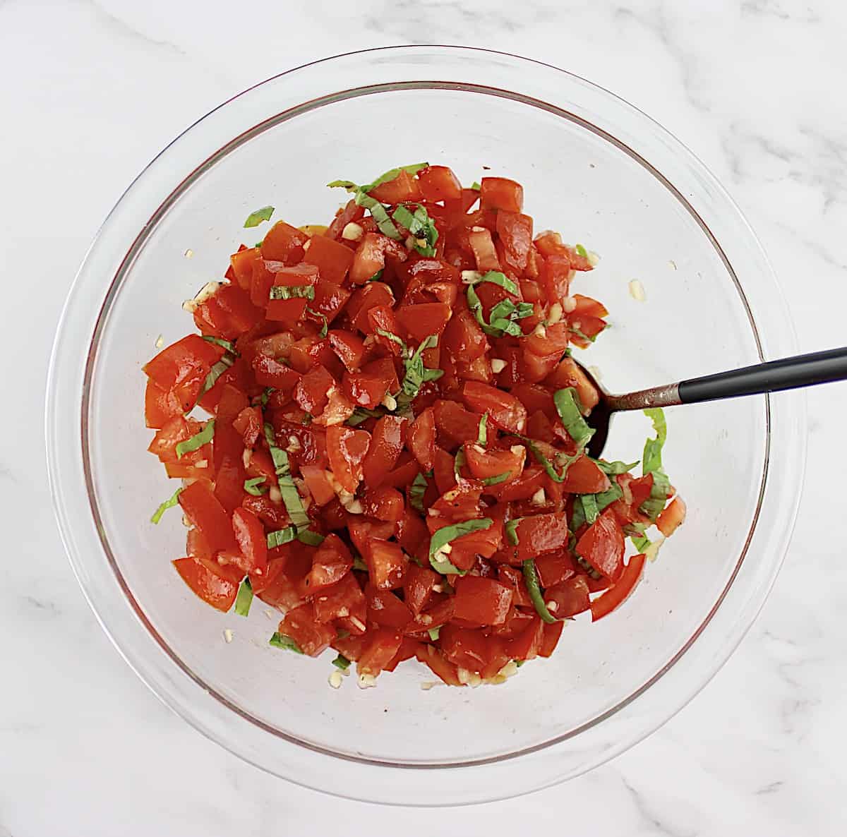 Easy Bruschetta mixture in glass bowl with spoon