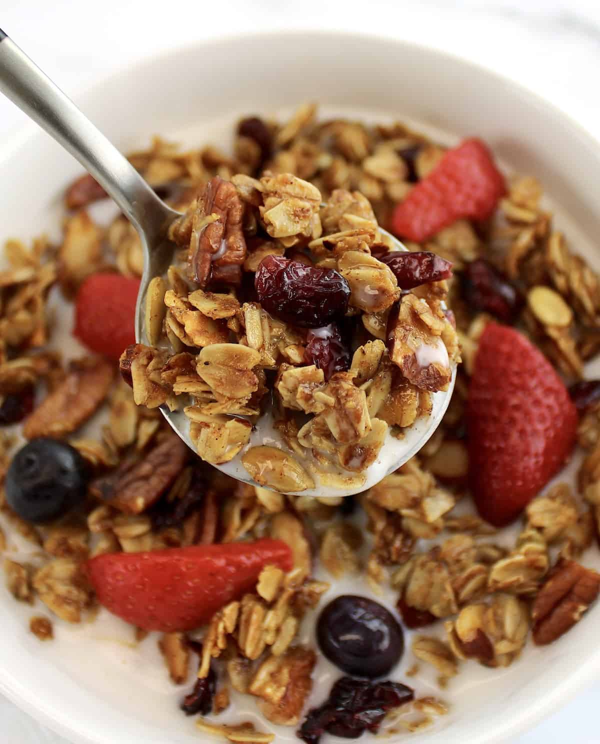 Homemade Granola cereal being spooned over bowl