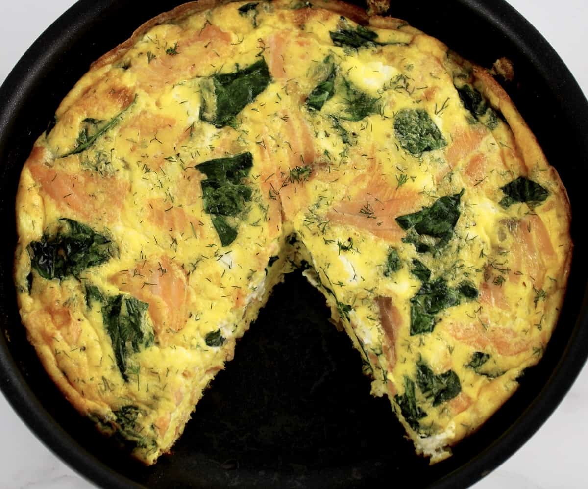 Smoked Salmon Frittata in skillet with slice missing