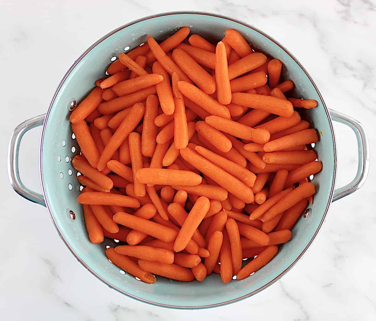 baby carrots in blue strainer