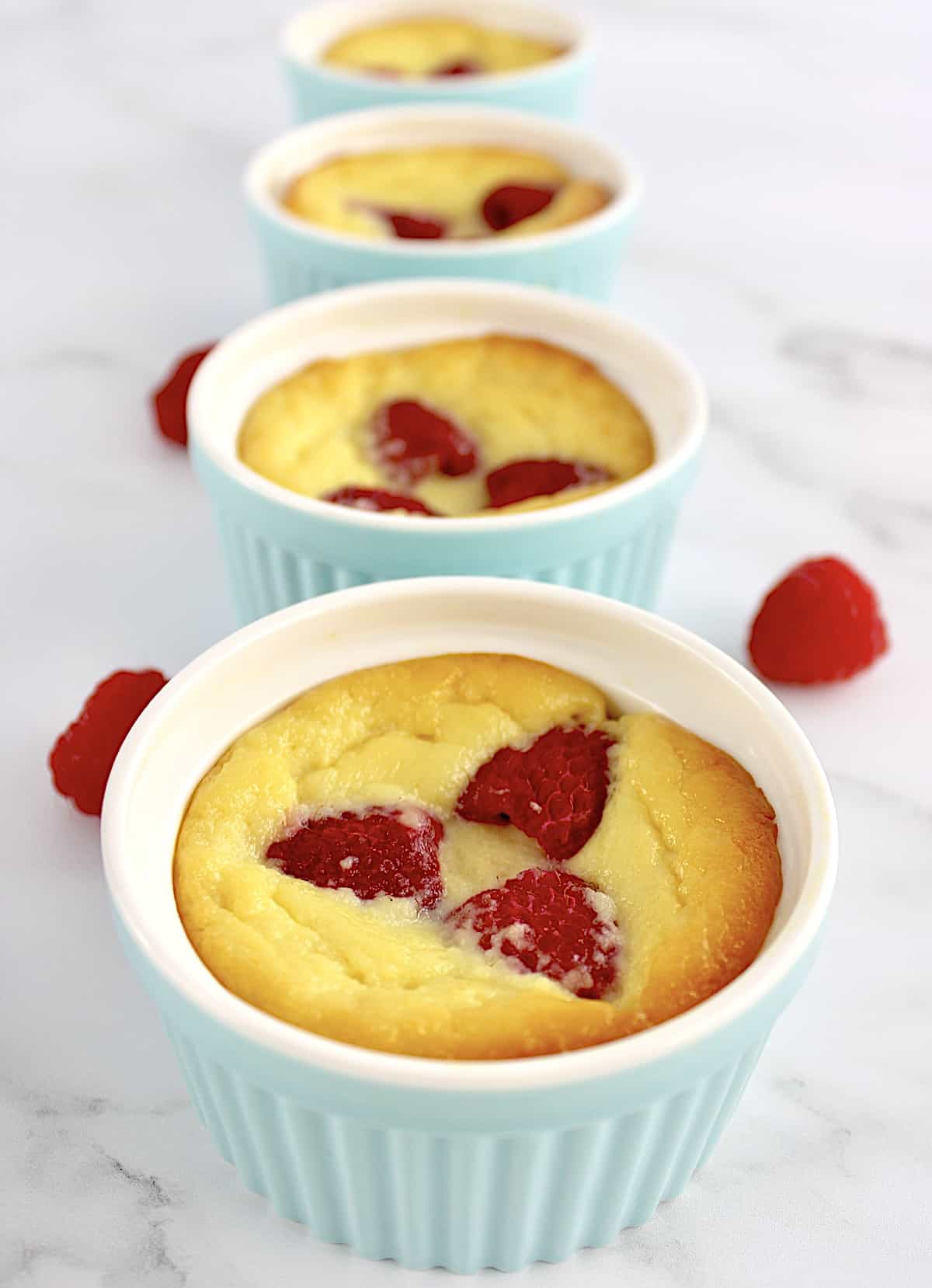 Baked Ricotta Raspberry Puddings lined up in a row