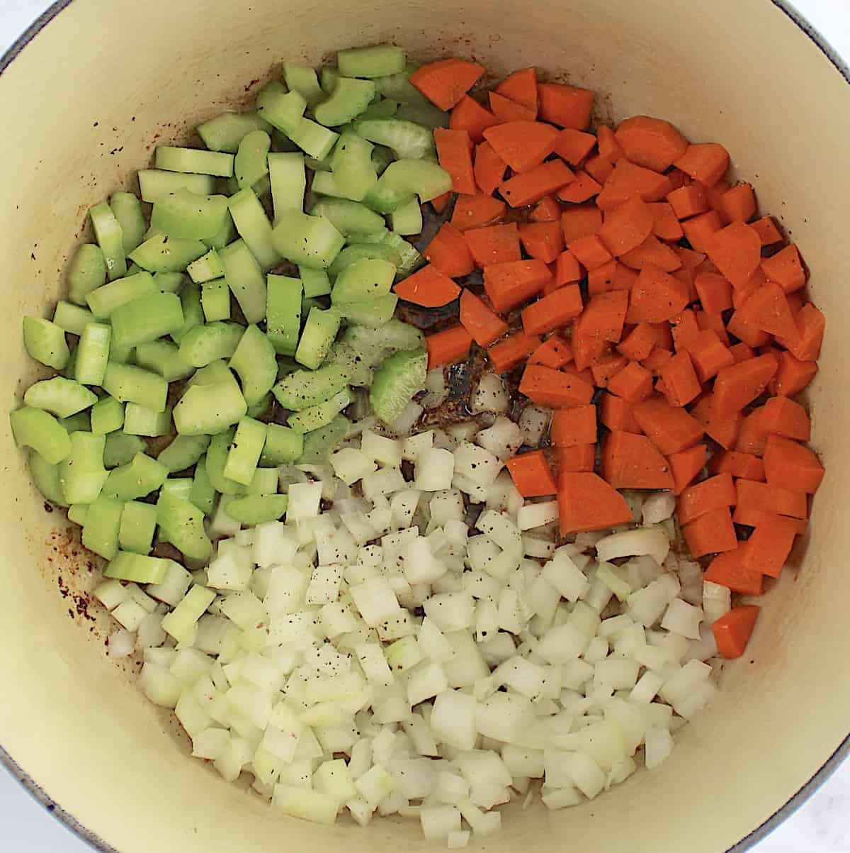chopped carrots, onions and celery cooking in pot