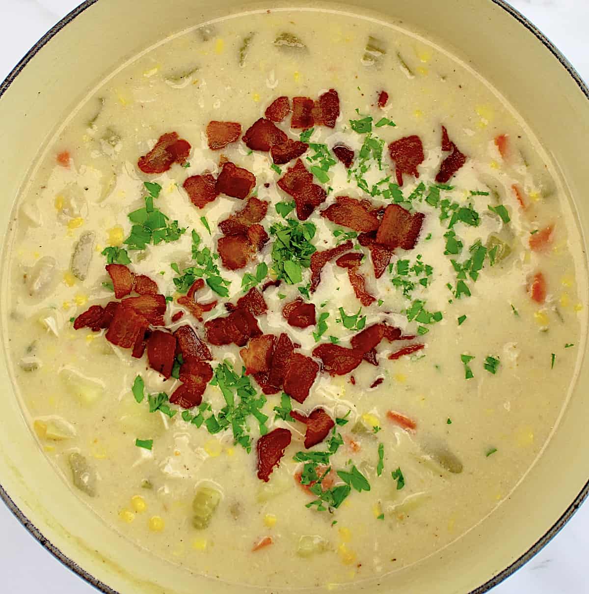 Chicken Corn Chowder in pot with chopped parsley and bacon on top