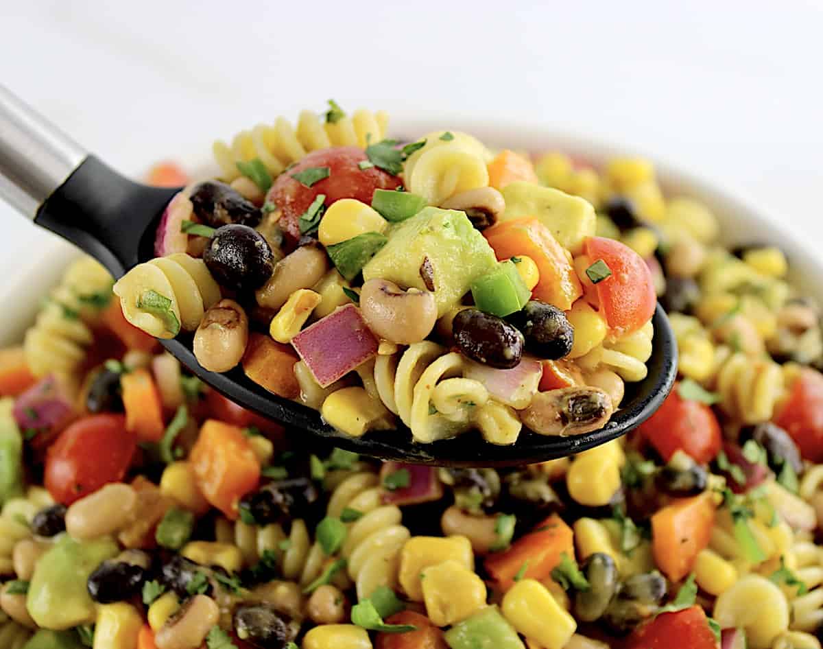 Cowboy Caviar Pasta Salad being held up by black serving spoon