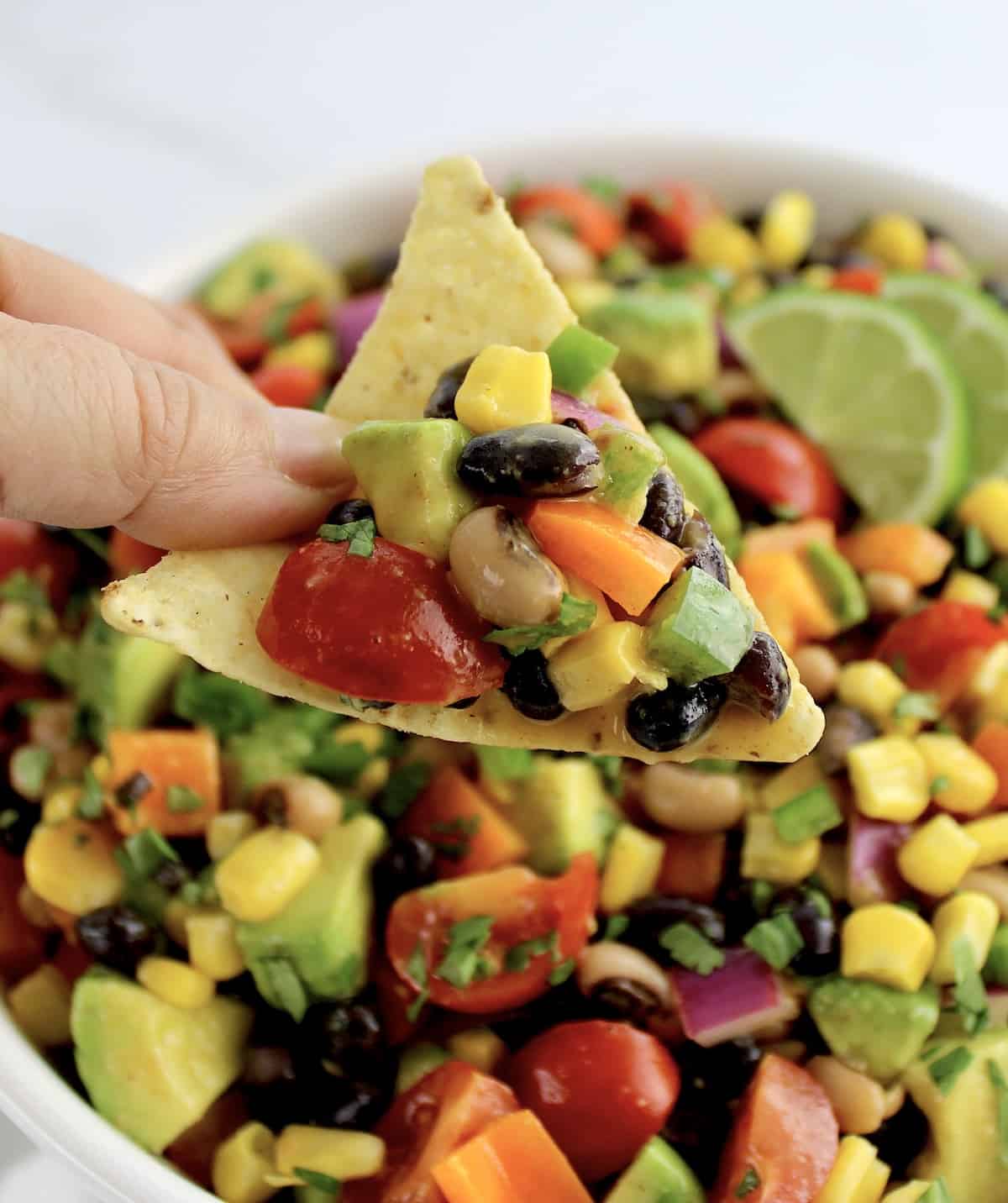 holding up tortilla chip with cowboy caviar