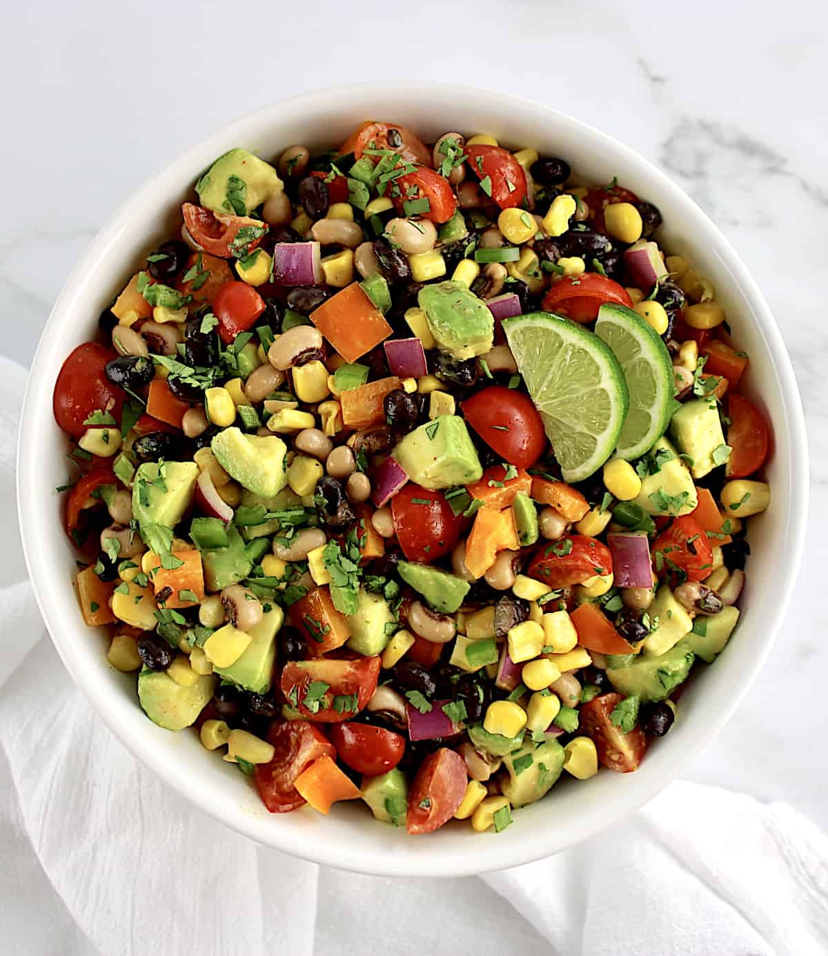 Cowboy Caviar in white bowl with 2 lime slices