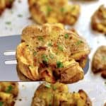 Crispy Smashed Potato on spatula held up over baking sheet