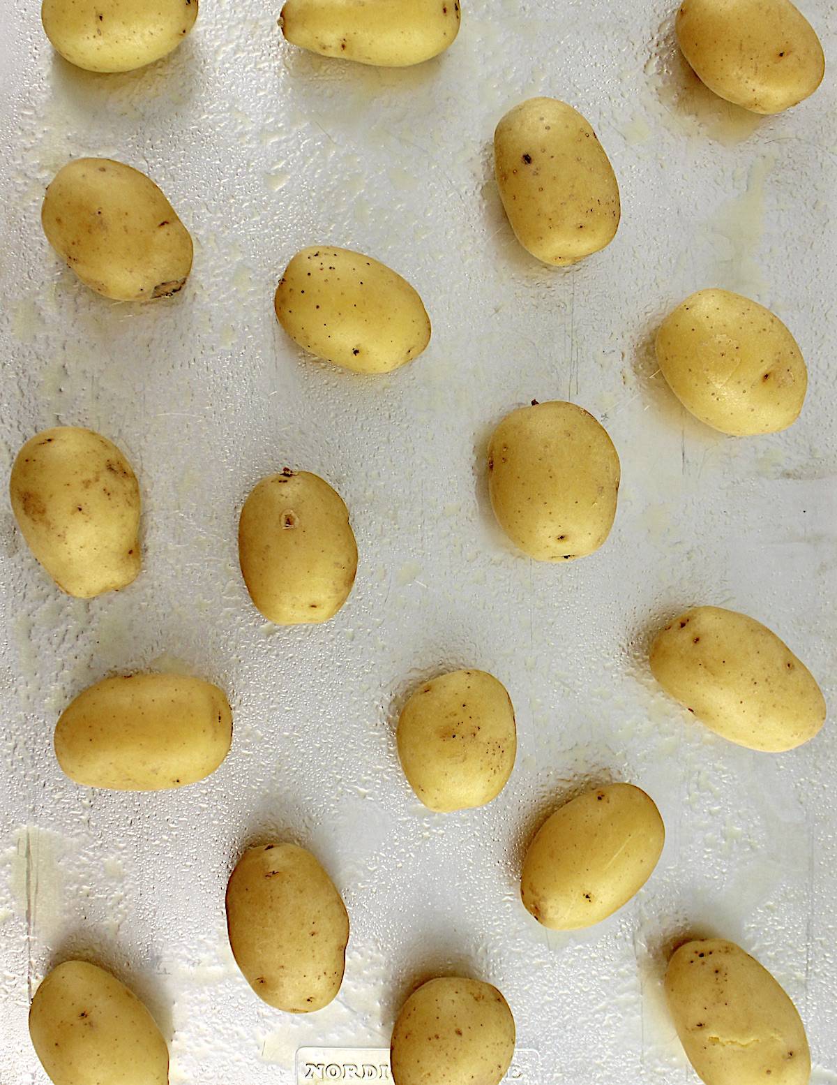 Cooked baby yukon gold potatoes on baking sheet