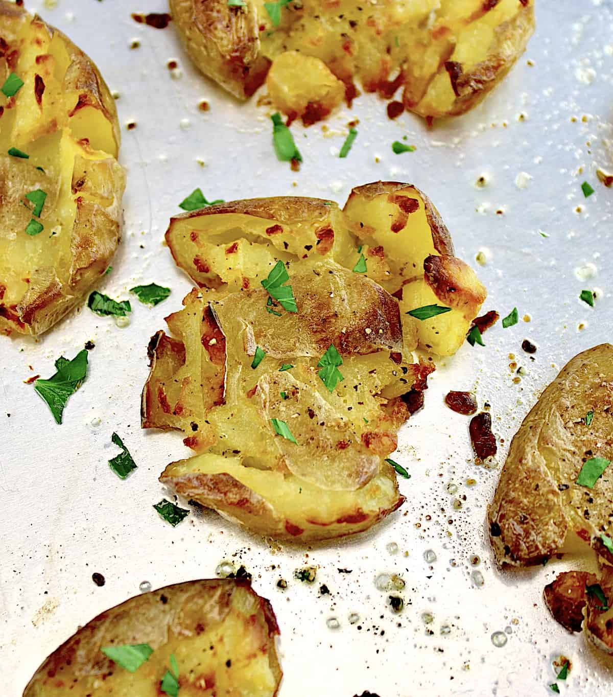 Crispy Smashed Potatoes on baking sheet with chopped parsley