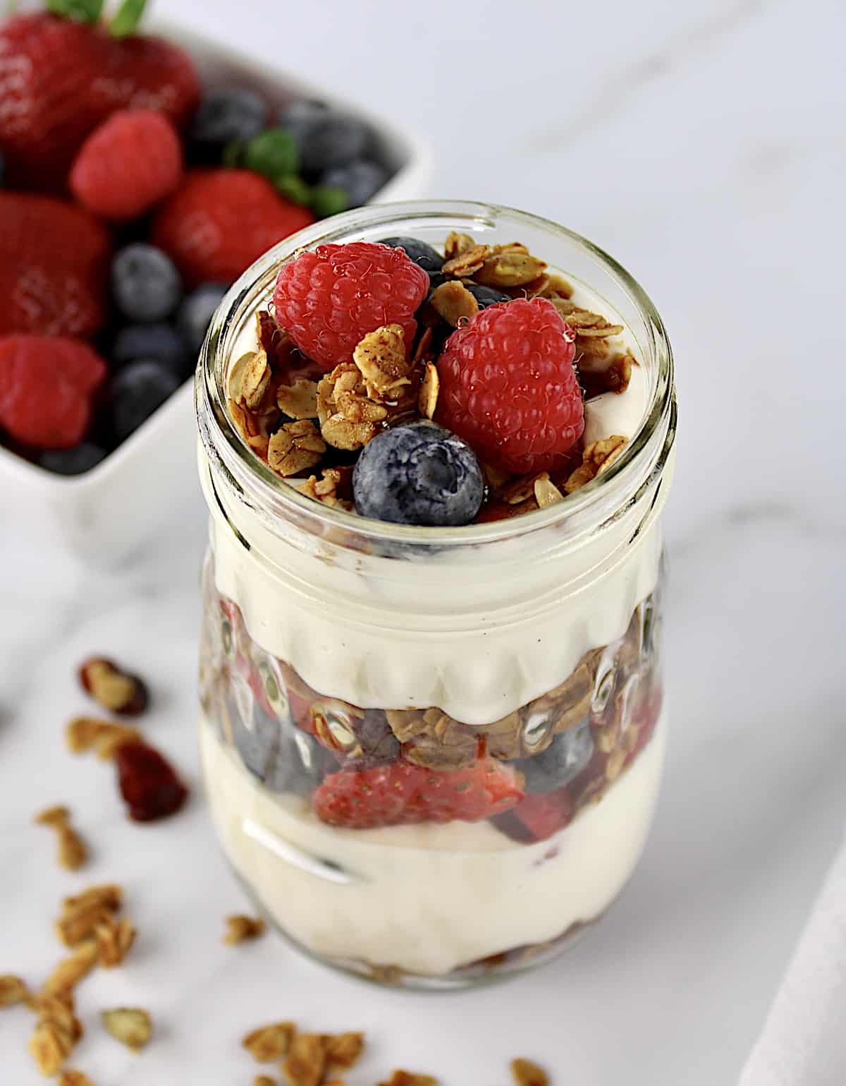 closeup of Easy Granola Parfait with berries in background