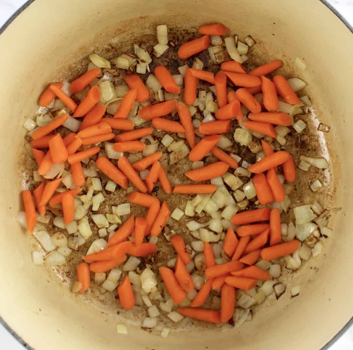 carrots and diced onions cooking in dutch oven