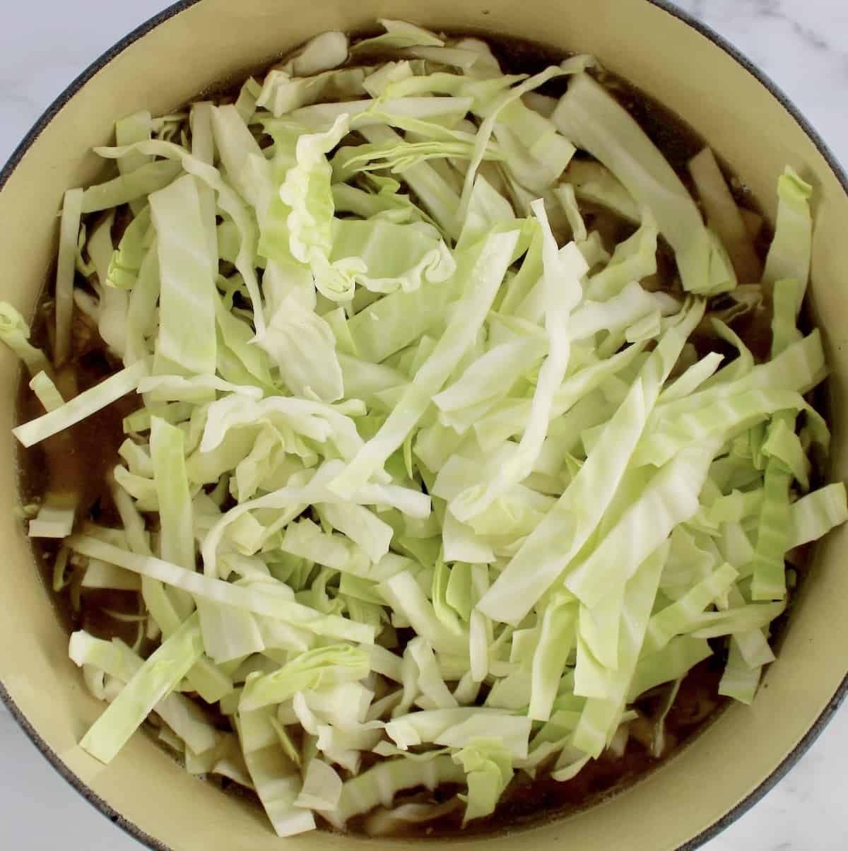 shredded cabbage in soup in dutch oven