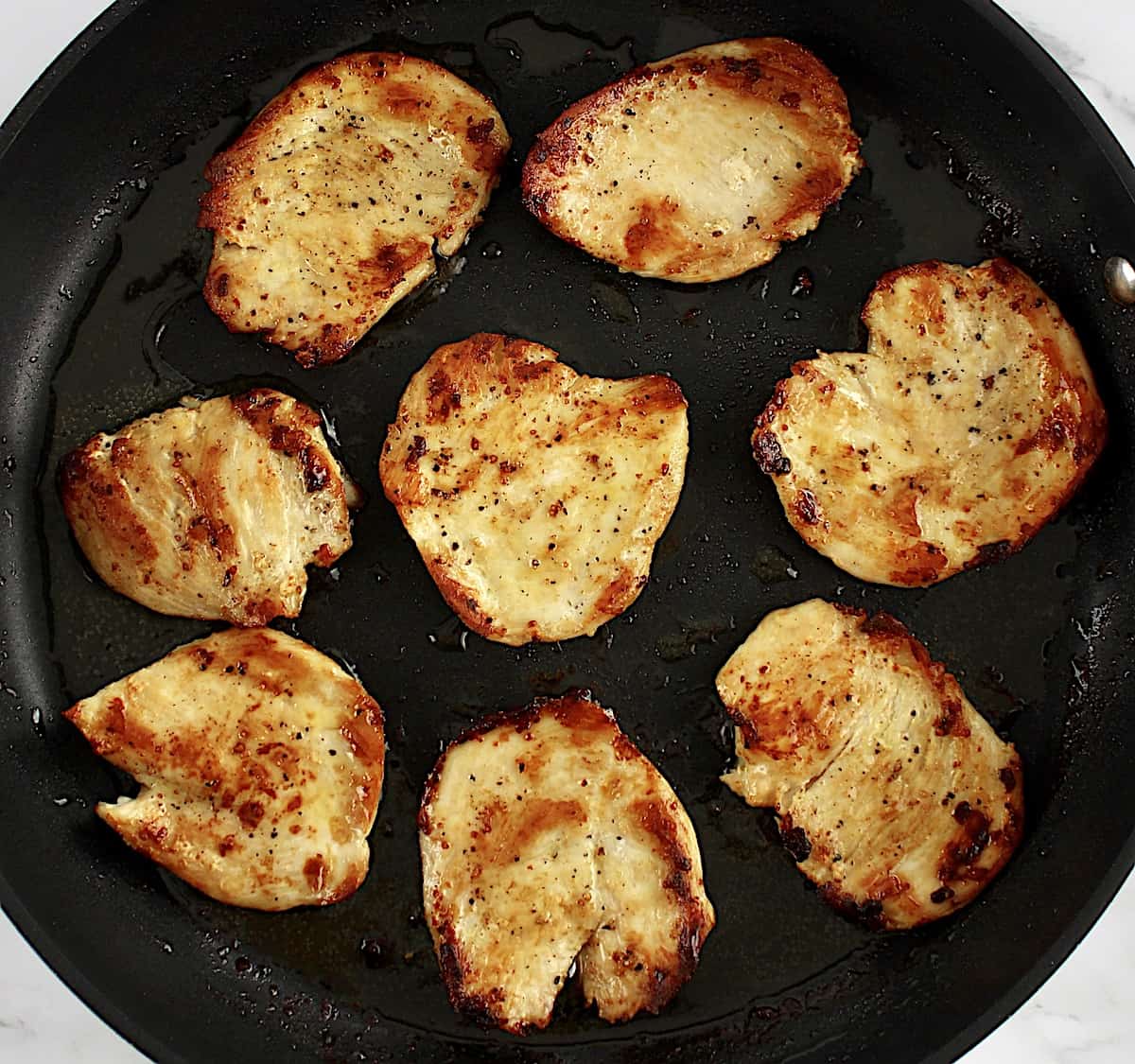 8 pieces of cooked chicken in skillet