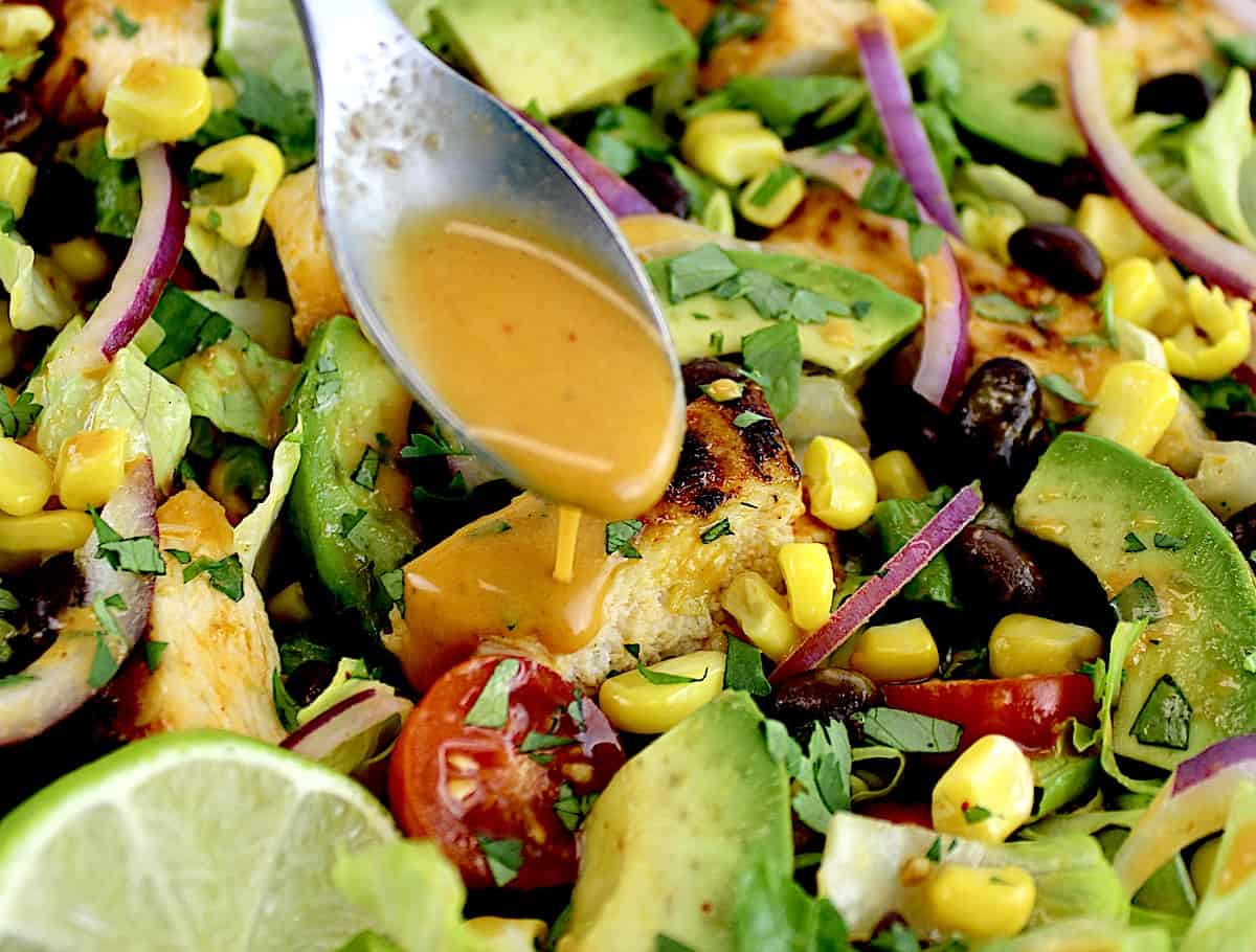 dressing being spooned over Southwest Chicken Salad