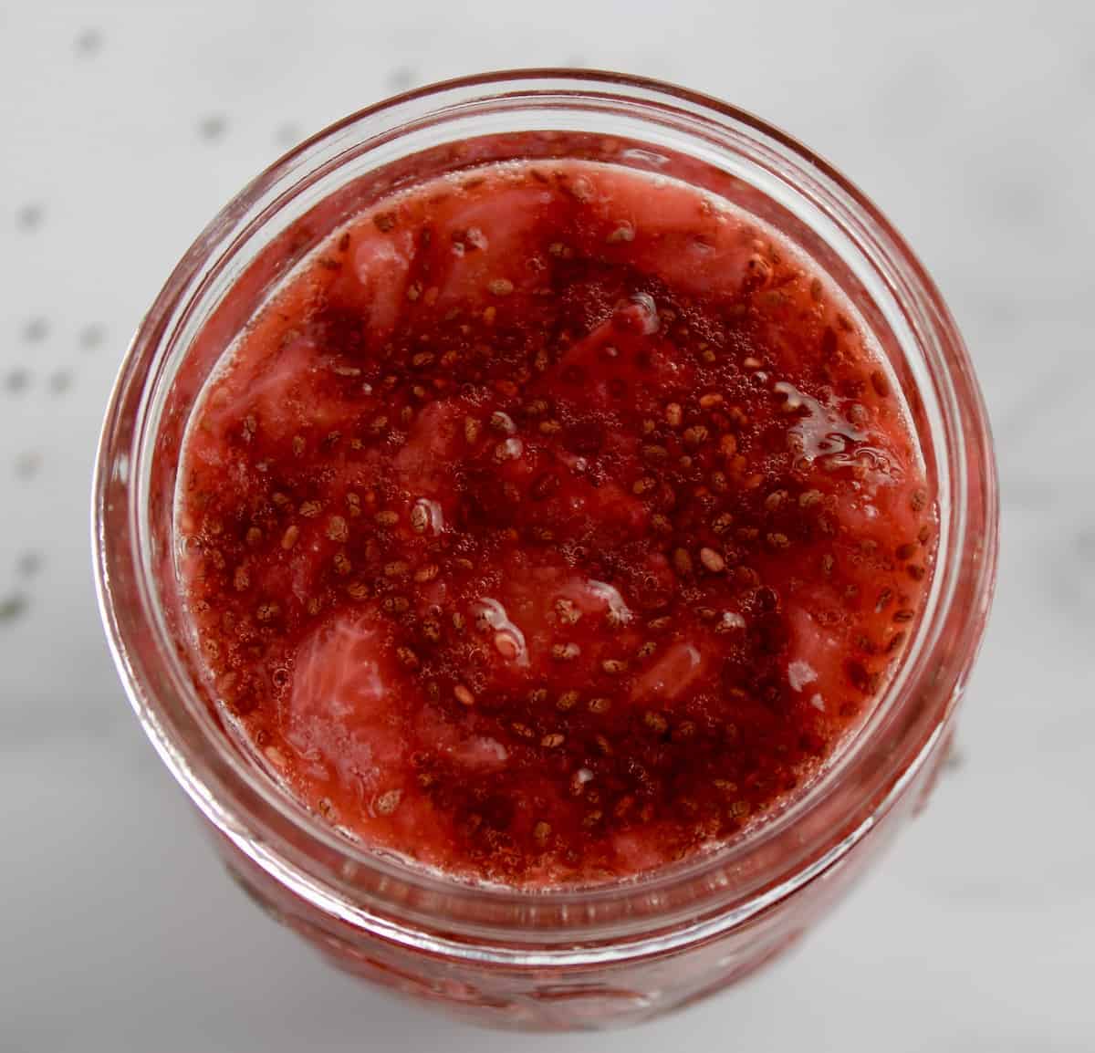 overhead view of Strawberry Chia Seed Jam in open glass jar