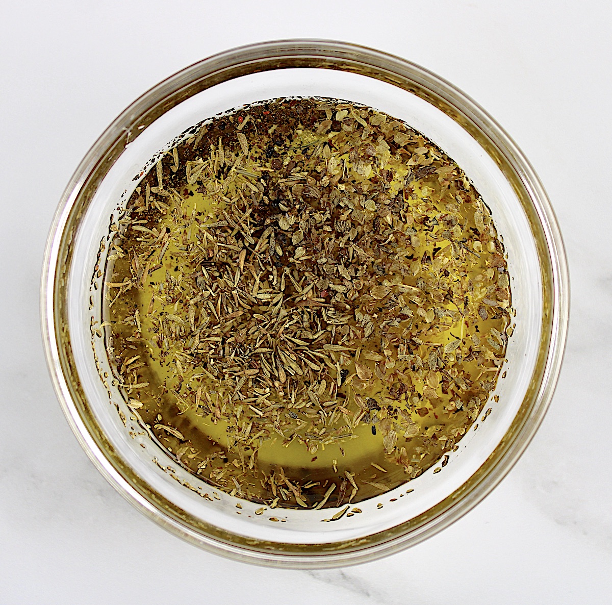 dried herbs and olive oil in glass bowl