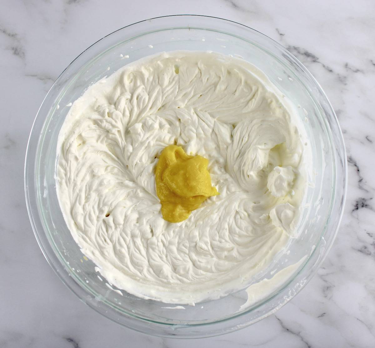 whip cream with dollop of lemon curd in center