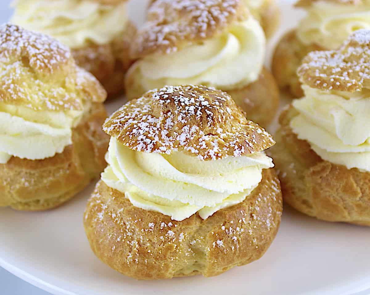 Lemon Cream Puffs on white plate with powdered sugar on top