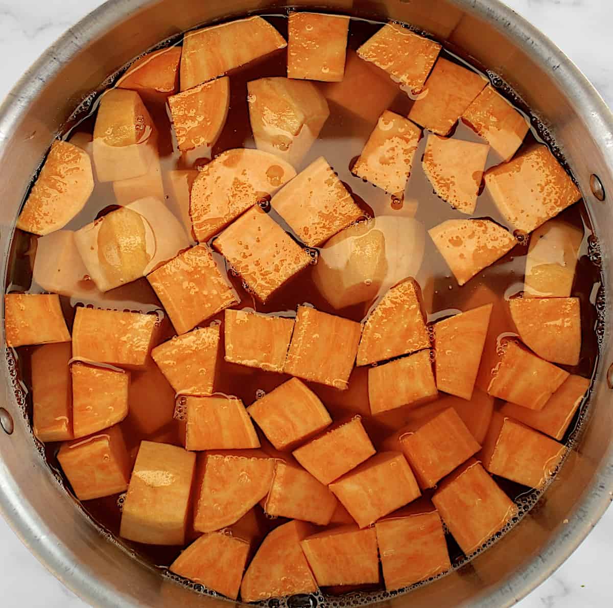 chopped sweet potatoes in pot of water