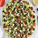 overhead view of Mediterranean Chopped Salad on white oval platter