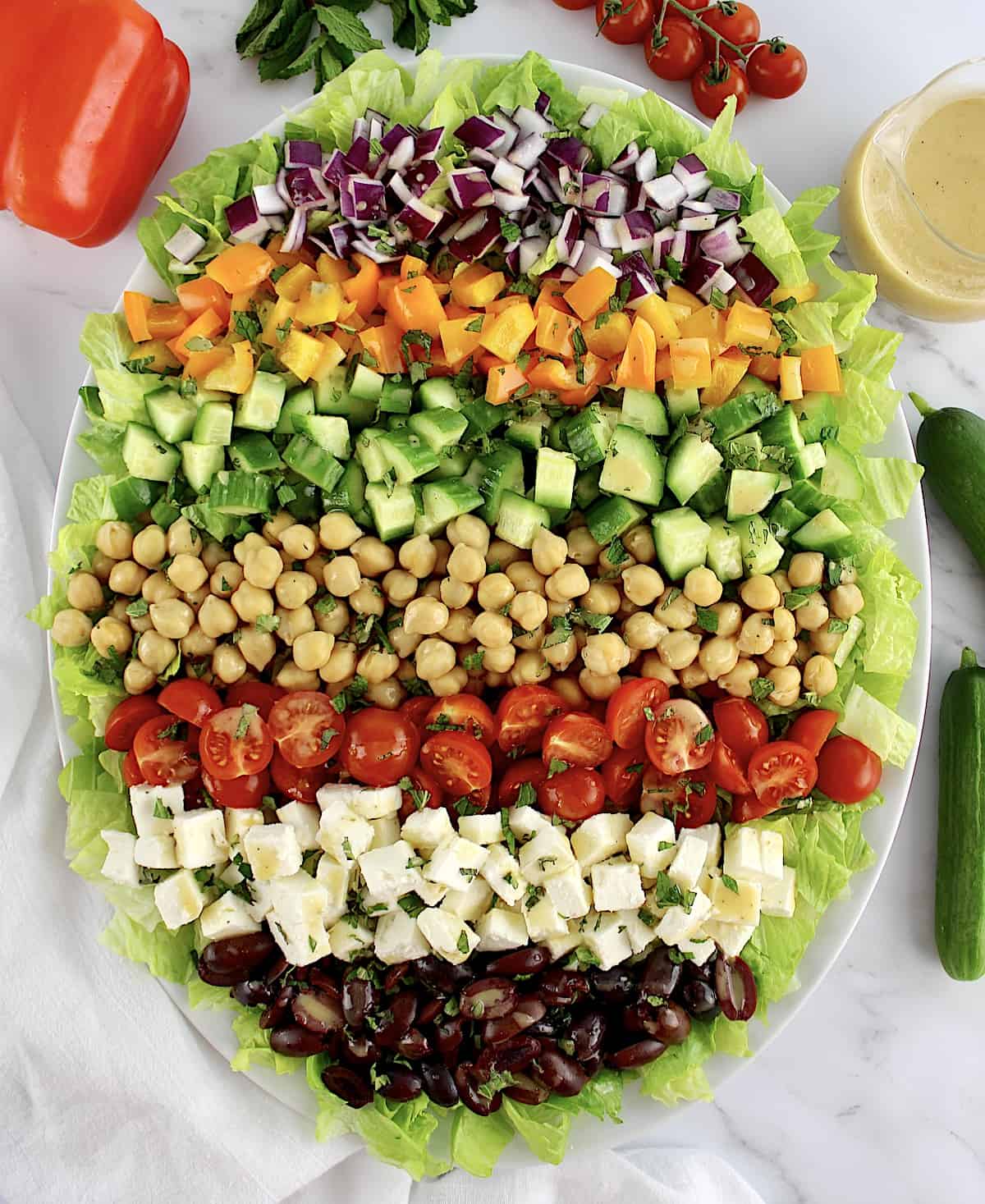 Mediterranean Chopped Salad in white oval platter with veggies arranged in rows
