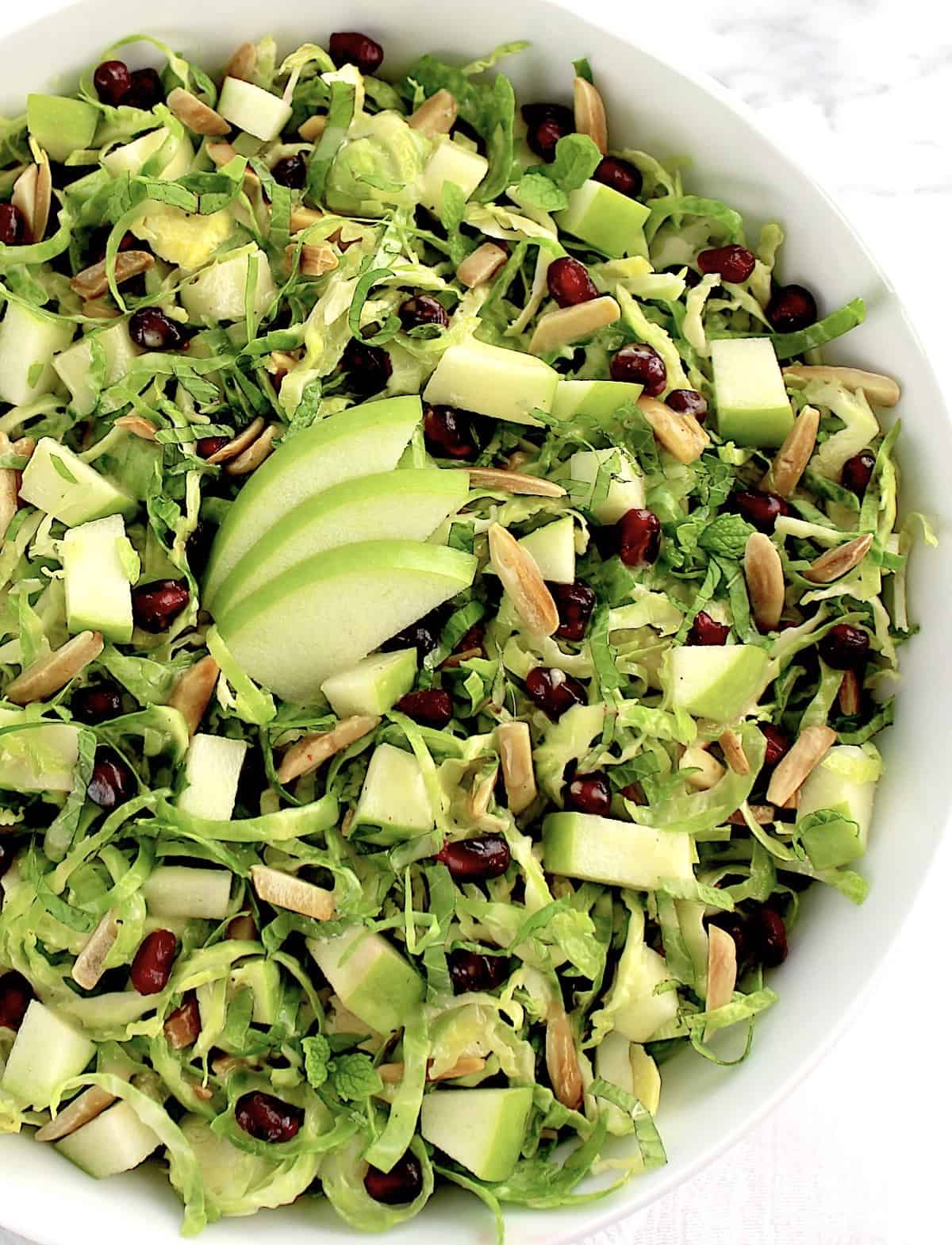 Shredded Brussels Sprouts Salad with 3 sliced green apples in center