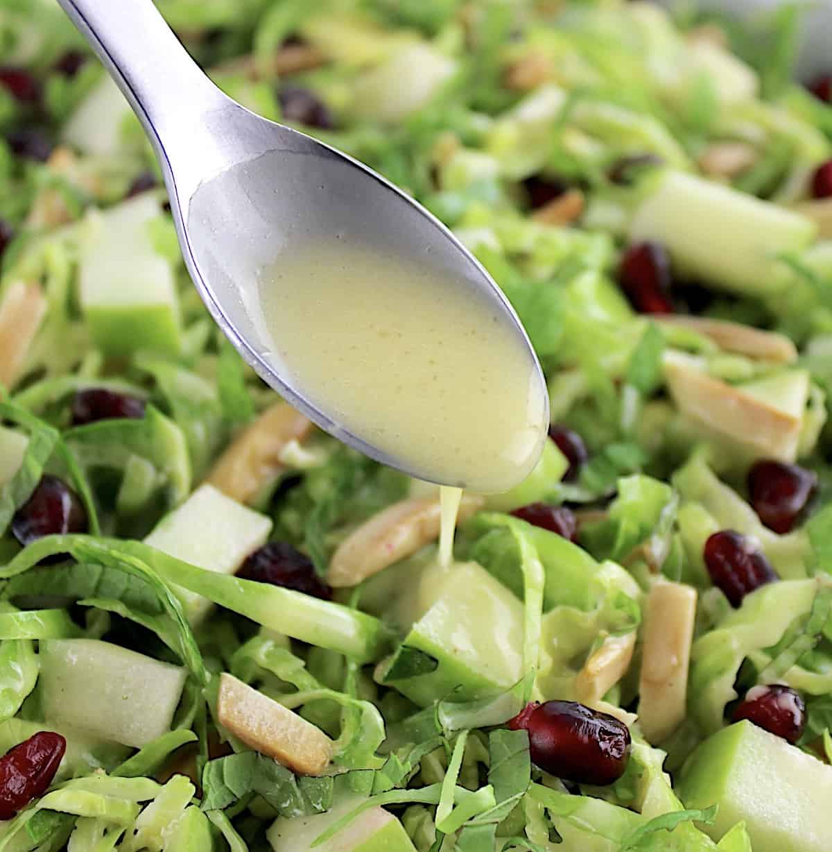 dressing being spooned over Shredded Brussels Sprouts Salad