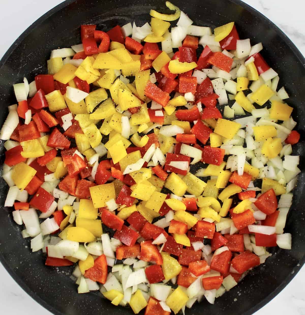 red and yellow peppers with onions in skillet