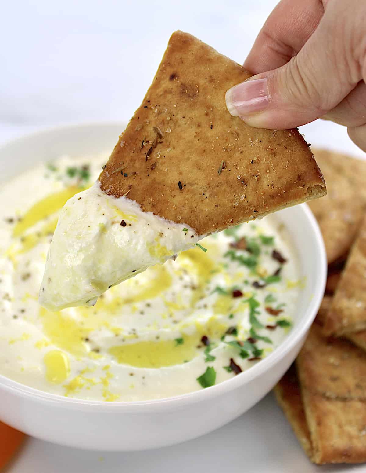 Homemade Pita Chip being dipped in whipped feta dip