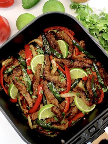 Air Fryer Steak Fajitas i air fryer basket with veggies in background