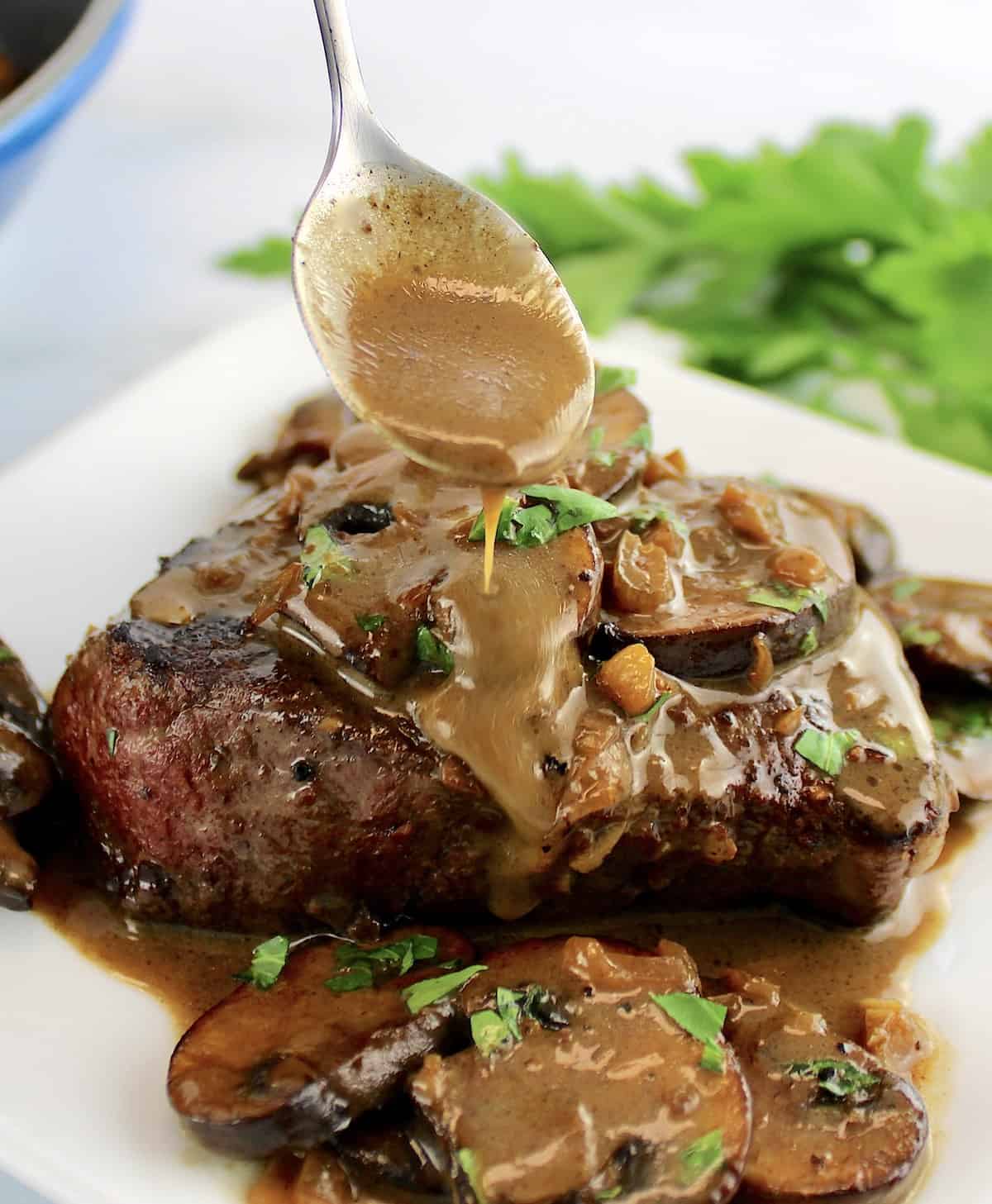 Filet Mignon with Mushroom Sauce with sauce being spooned over top